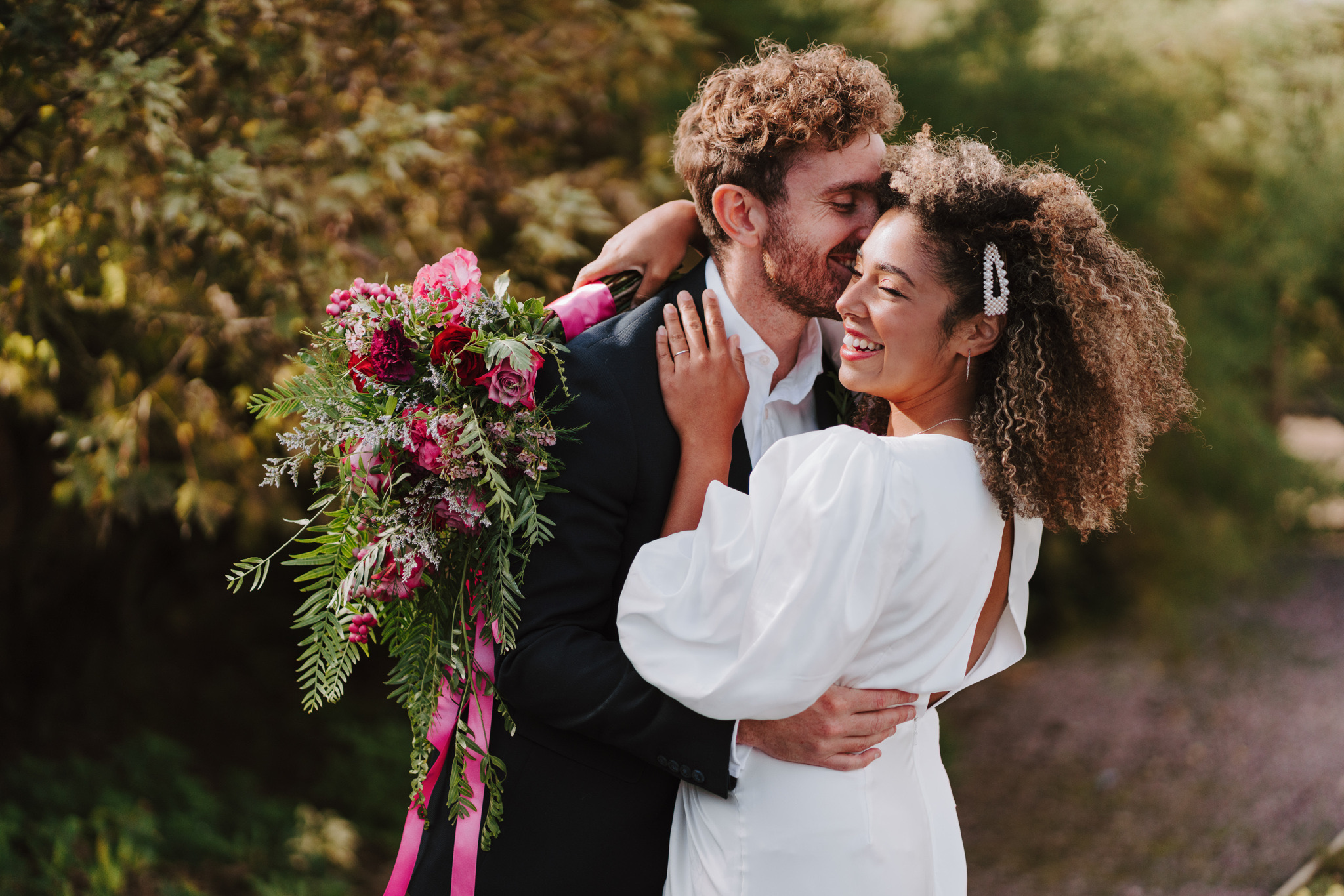 Bride and groom laughing with a bright pink cascading bouquet, Dionne and Alistair's manor house wedding in Lincolnshire