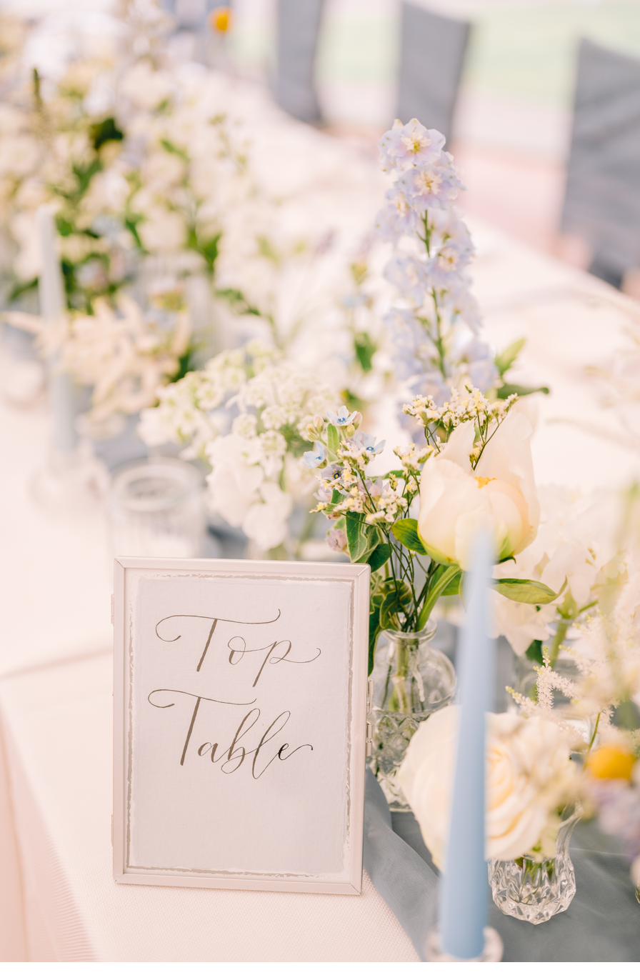 Top table sign and flowers, Lucia and Alex's marquee wedding in Rutland