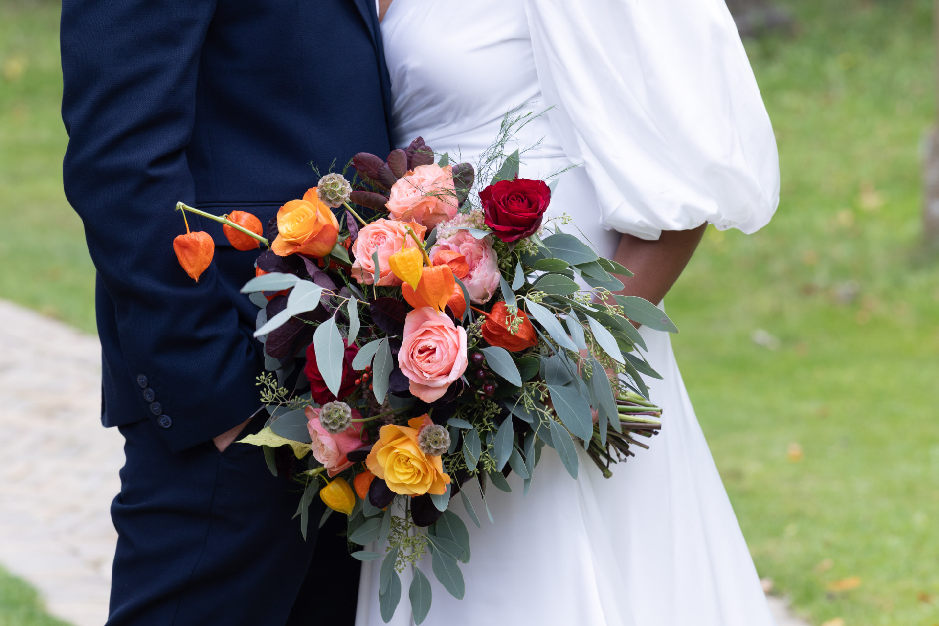 Coral, raspberry and burgundy bridal bouquet with eucalyptus, Dionne and Alistair's manor house wedding in Lincolnshire